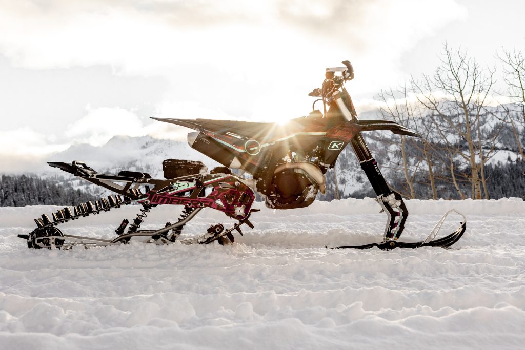 Custom Timbersled graphic kit snow bike wrap glowing at sunset in the mountains