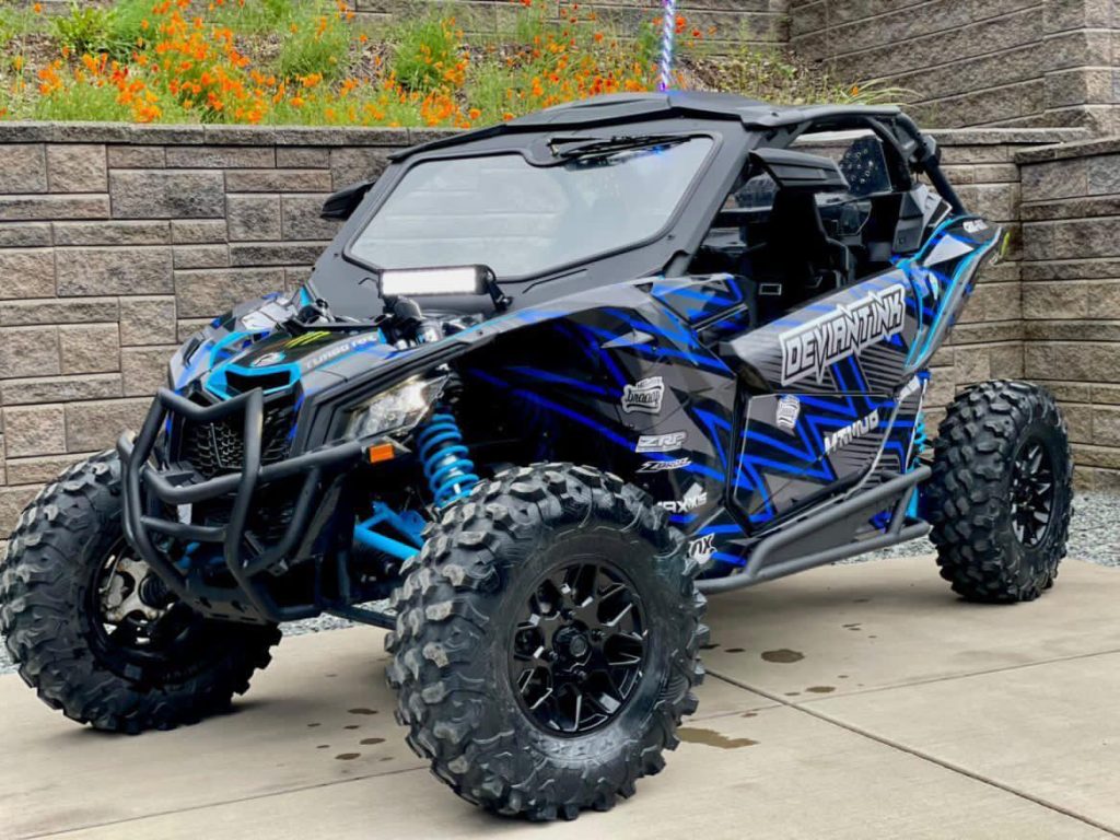 Custom Can-Am Maverick X3 wrapped in blue and black Deviant Ink graphics with aggressive styling
